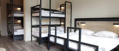 A room with bunk beds, a wooden headboard, and built-in shelves.