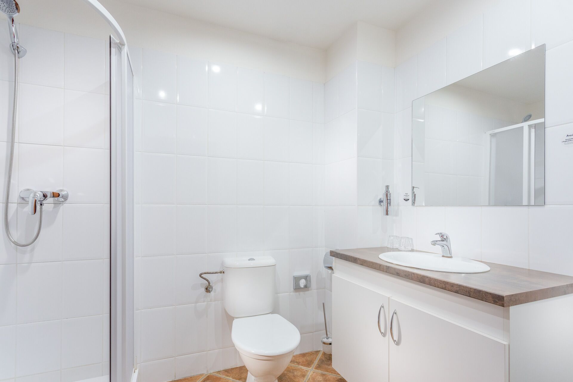A modern bathroom with a toilet, sink, and shower.
