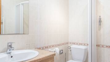 A bathroom with a sink, toilet, and shower.