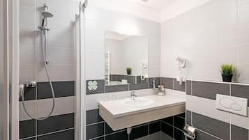 A modern bathroom with a shower, sink, and mirror.