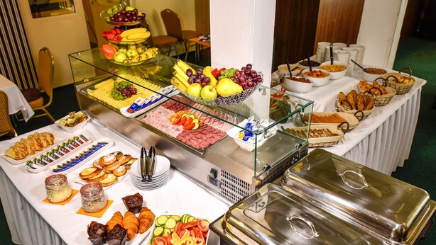 A buffet with various food items including fruits, pastries, and salads. - City Hotel (Brno)