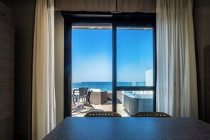 A room with a large sliding glass door leading to a balcony with a view of the ocean. - Residence Picalè (Alghero)