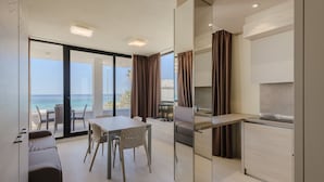 A modern hotel room with a balcony, a dining area, and a kitchen. - Residence Picalè (Alghero)