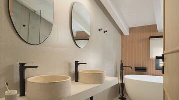 Une salle de bain moderne avec deux lavabos, une grande baignoire et deux miroirs.