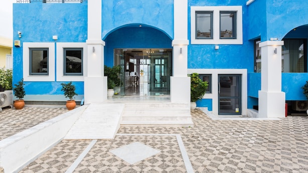 A blue building with the sign "Palazzo Greco" and a tiled entrance area. - Palazzo Greco (Agios Vasileios)