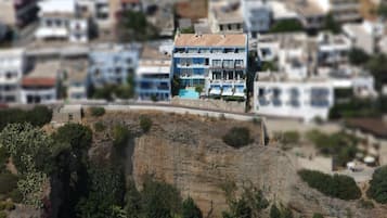 A coastal town with a prominent building featuring balconies and a waterfront view.