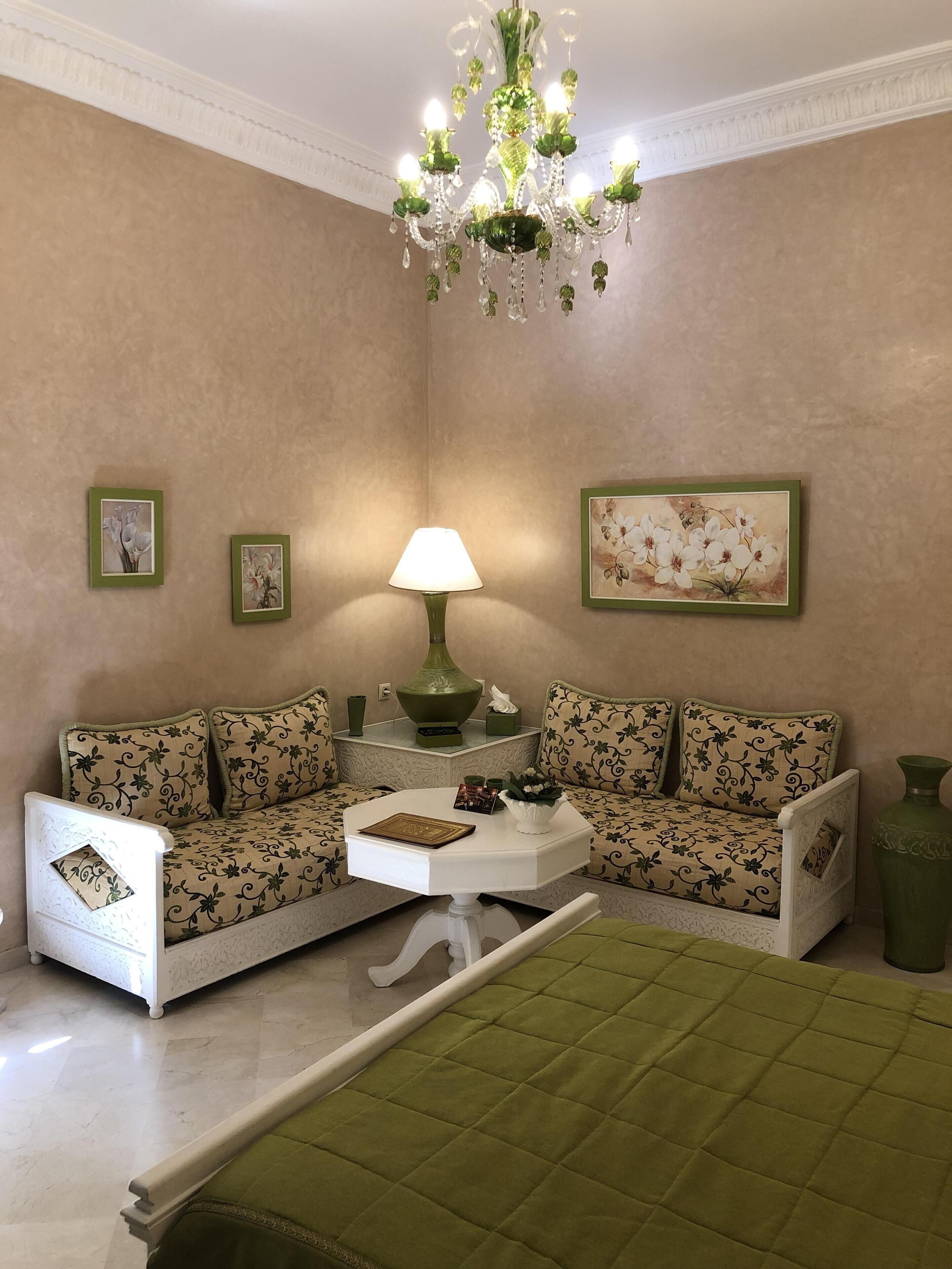 A cozy living room with a sofa set, a coffee table, a lamp, and a chandelier.