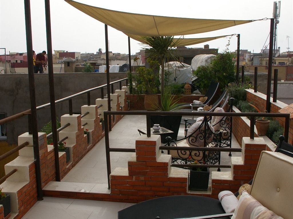 Une terrasse sur le toit, dotée d’un espace salon, d’un escalier et offrant une vue sur le paysage urbain.
