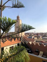 Terraço no terraço com vista para um horizonte urbano, incluindo uma torre e edifícios residenciais.