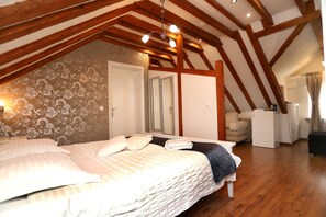 A bedroom with a wooden ceiling, a bed with white bedding, a dresser, and a mirror.