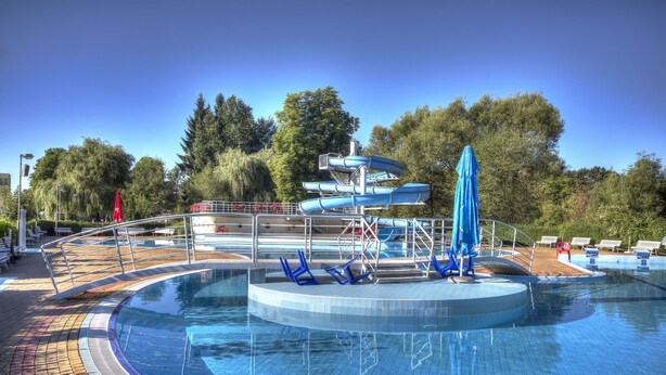 A swimming pool with a water slide, lounge chairs, and a covered area. - Hotel Záviš z Falkenštejna (Hluboka nad Vltavou)