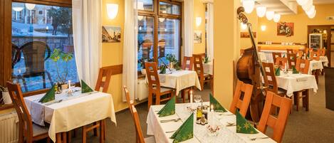 Un restaurante con varias mesas dispuestas para comer, que ofrece vistas a la calle.