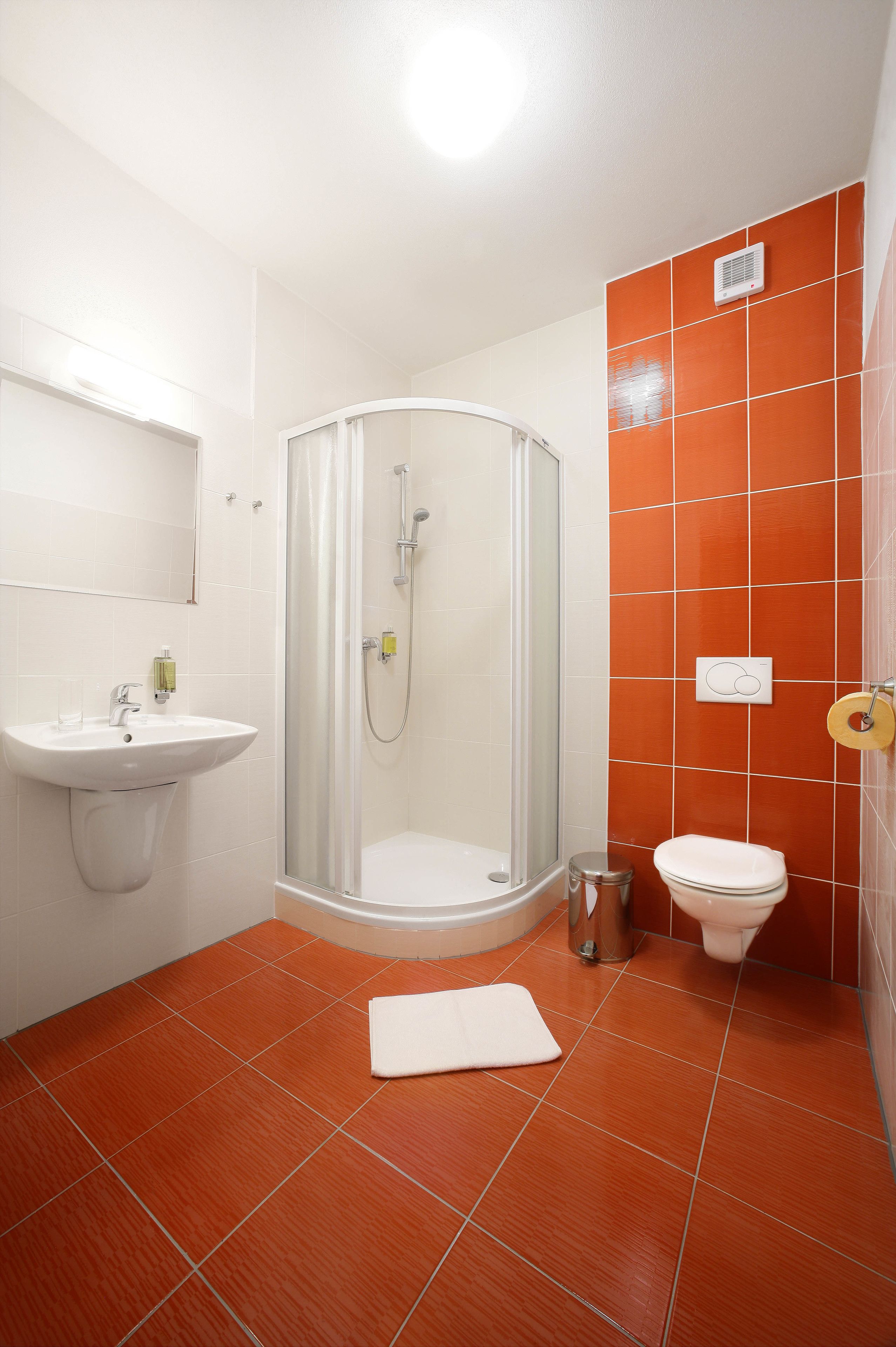 Une salle de bain avec une douche à parois de verre, un lavabo et des toilettes.