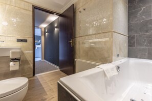 A modern bathroom with a bathtub, toilet, and sink.