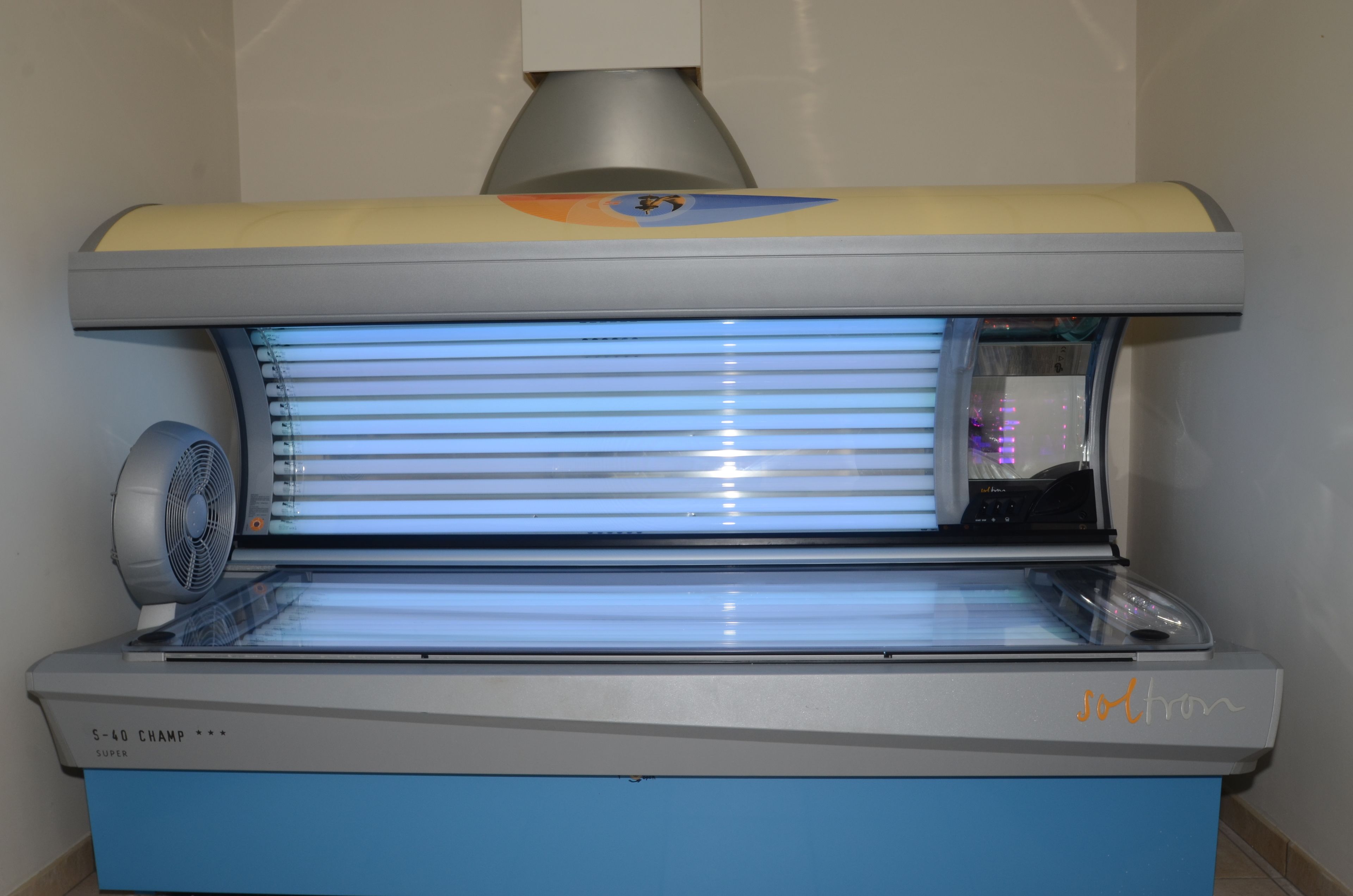 Un appareil de bronzage équipé d’un panneau de commande et d’un ventilateur.