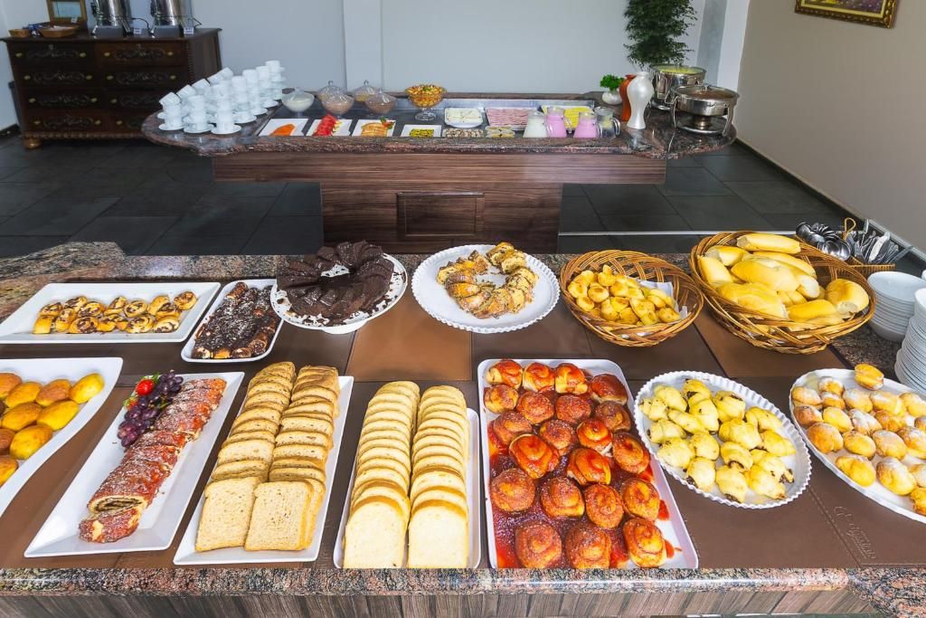 Ein Buffet mit verschiedenen Speisen, darunter Gebäck, Brot und Früchte.