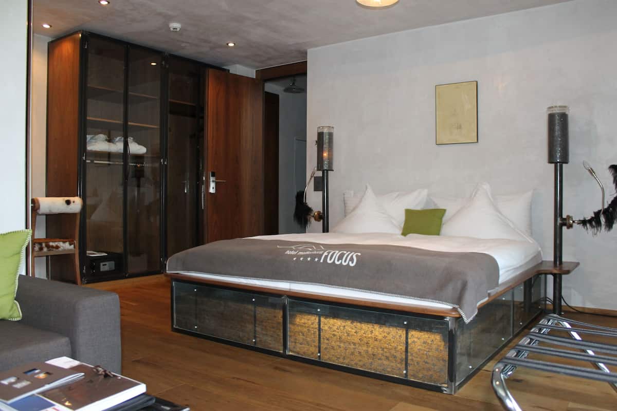Une chambre d’hôtel moderne, dotée d’un grand lit, d’une armoire, d’un bureau et d’une chaise.