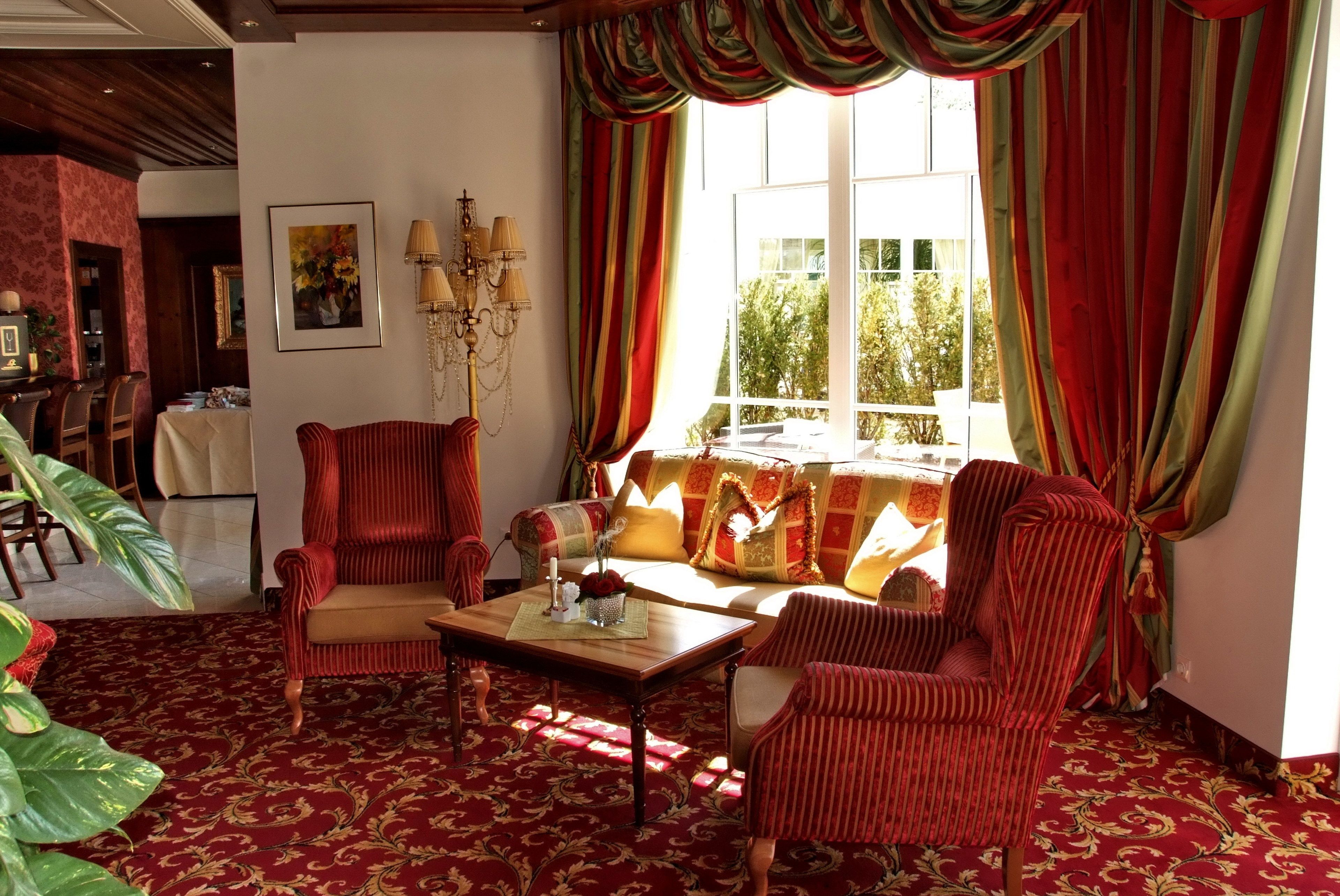 A living room with a sofa, armchairs, a coffee table, and a chandelier.