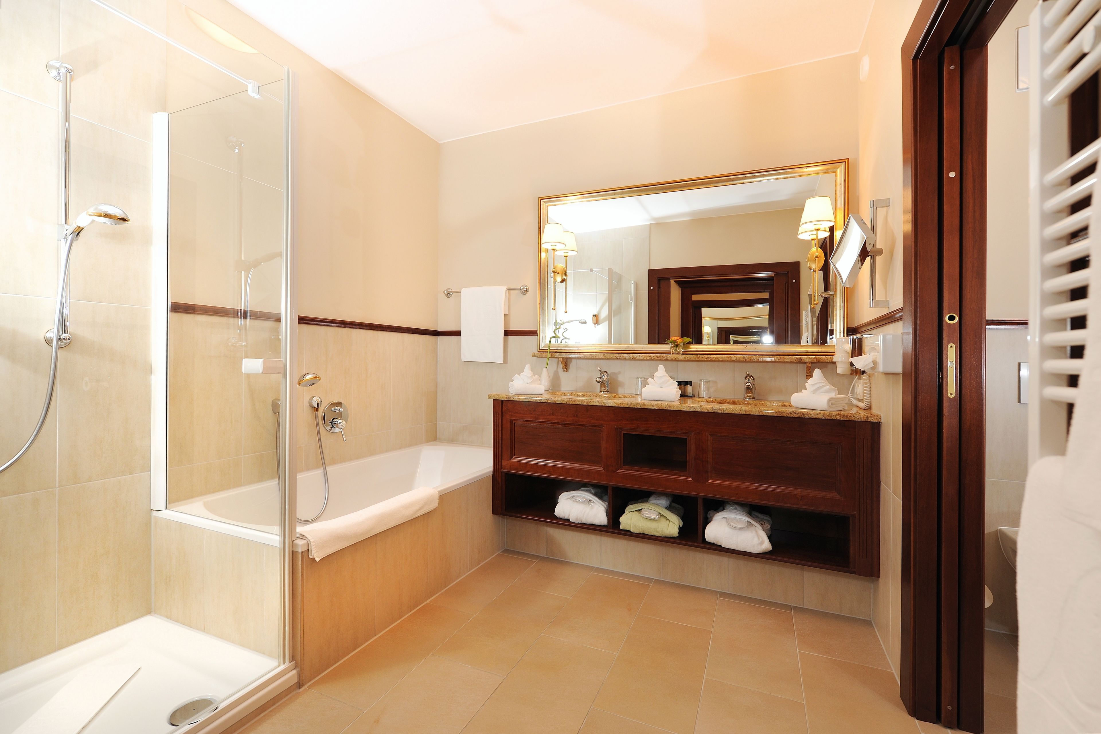 Une salle de bain moderne dotée d’une douche à parois de verre, d’une baignoire sur pieds et d’un meuble-lavabo avec un grand miroir.