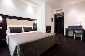 A hotel room with a large bed, a desk, and a chair. - La Villa Resort (Montecatini Terme)