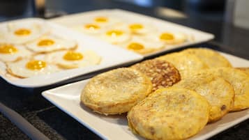 Une assiette de petit-déjeuner avec des œufs et des pommes de terre rissolées.