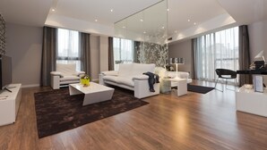 Una sala de estar moderna con un sofá blanco, una mesita de centro y un espejo grande.