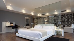 Un dormitorio moderno con una cama grande, un escritorio y una silla.