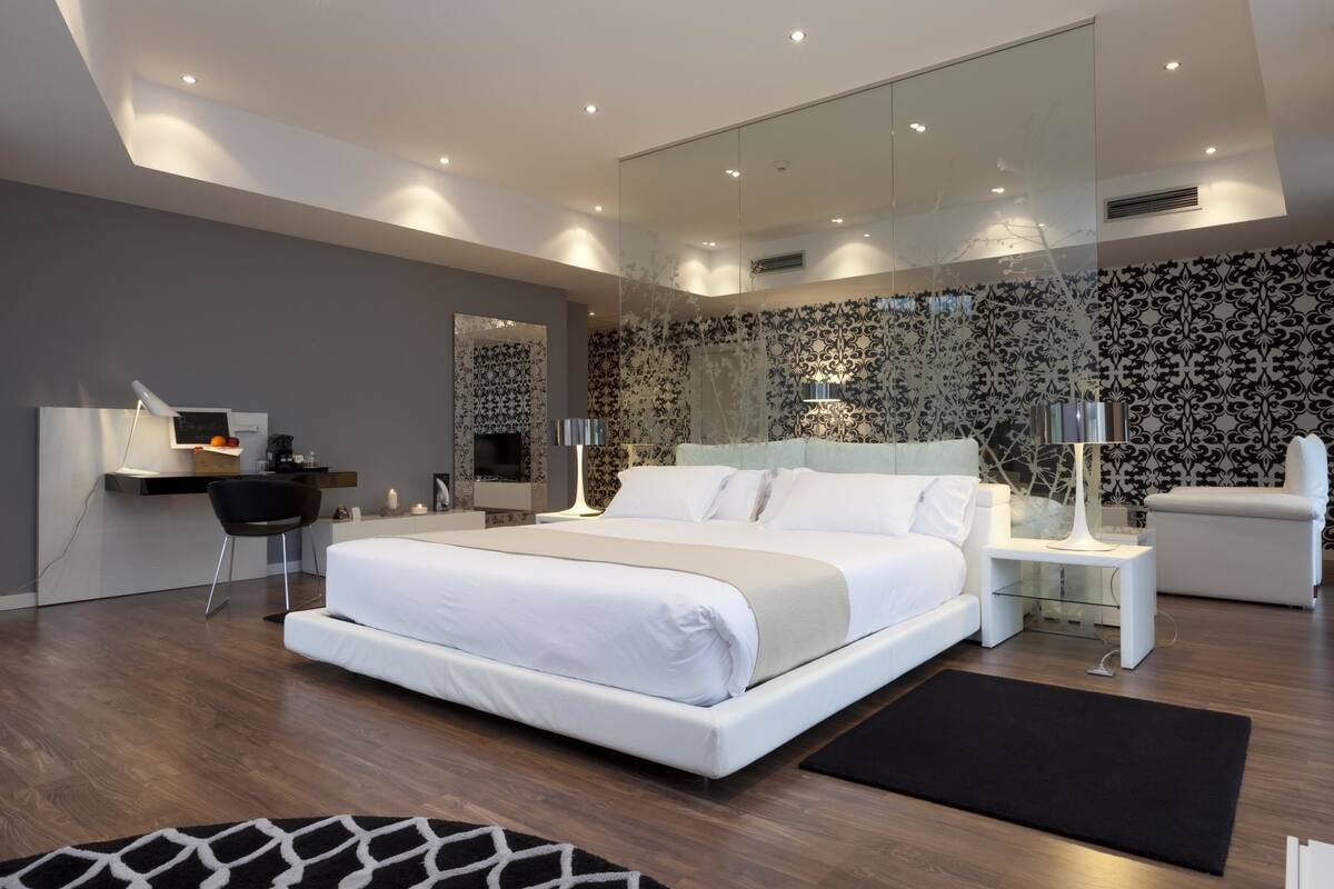 Una camera da letto moderna con un letto grande, una scrivania e una sedia.