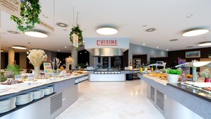 Un área de cocina moderna con un cartel que dice 'CUISINE', diversos alimentos y plantas decorativas.