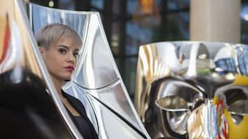 Una persona sentada en una mesa con una superficie metálica y reflectante.