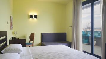 Une chambre d’hôtel avec un lit, un bureau, une chaise et une vue sur l’extérieur.