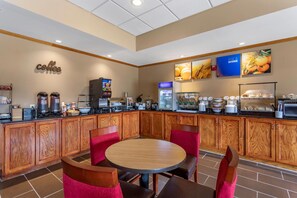 Espaço de café da manhã com estação de café, assentos e geladeira.