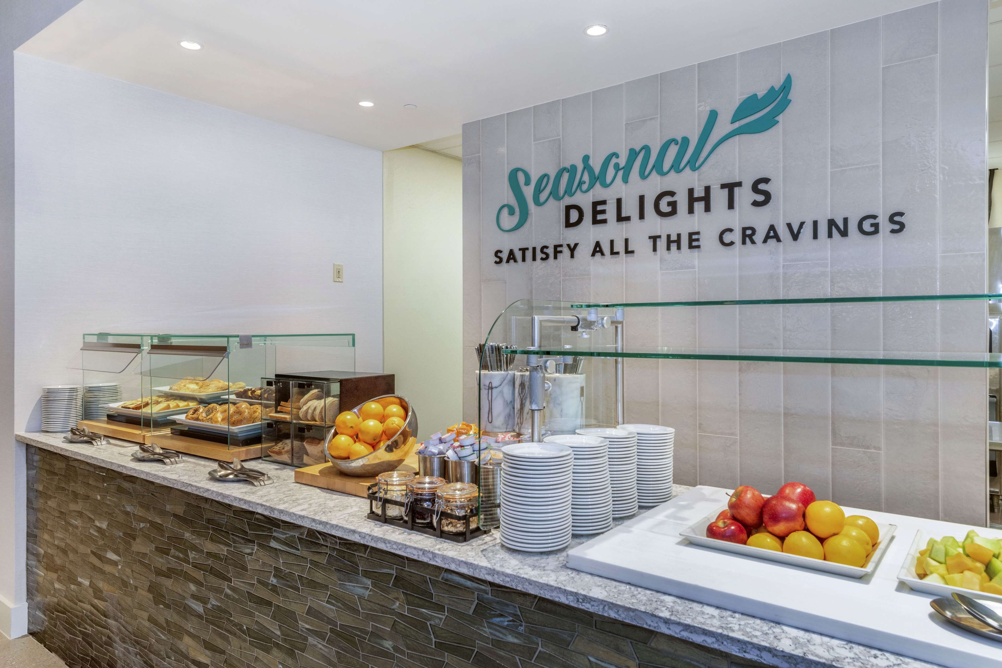 A buffet counter with a sign reading "Seasonal Delights Satisfy All the Cravings."