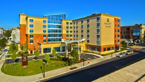 A multi-story hotel with a modern design, featuring a glass facade and a prominent "Hyatt Place" sign.