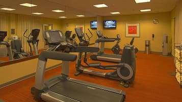 A hotel fitness center with treadmills, elliptical machines, and stationary bikes.