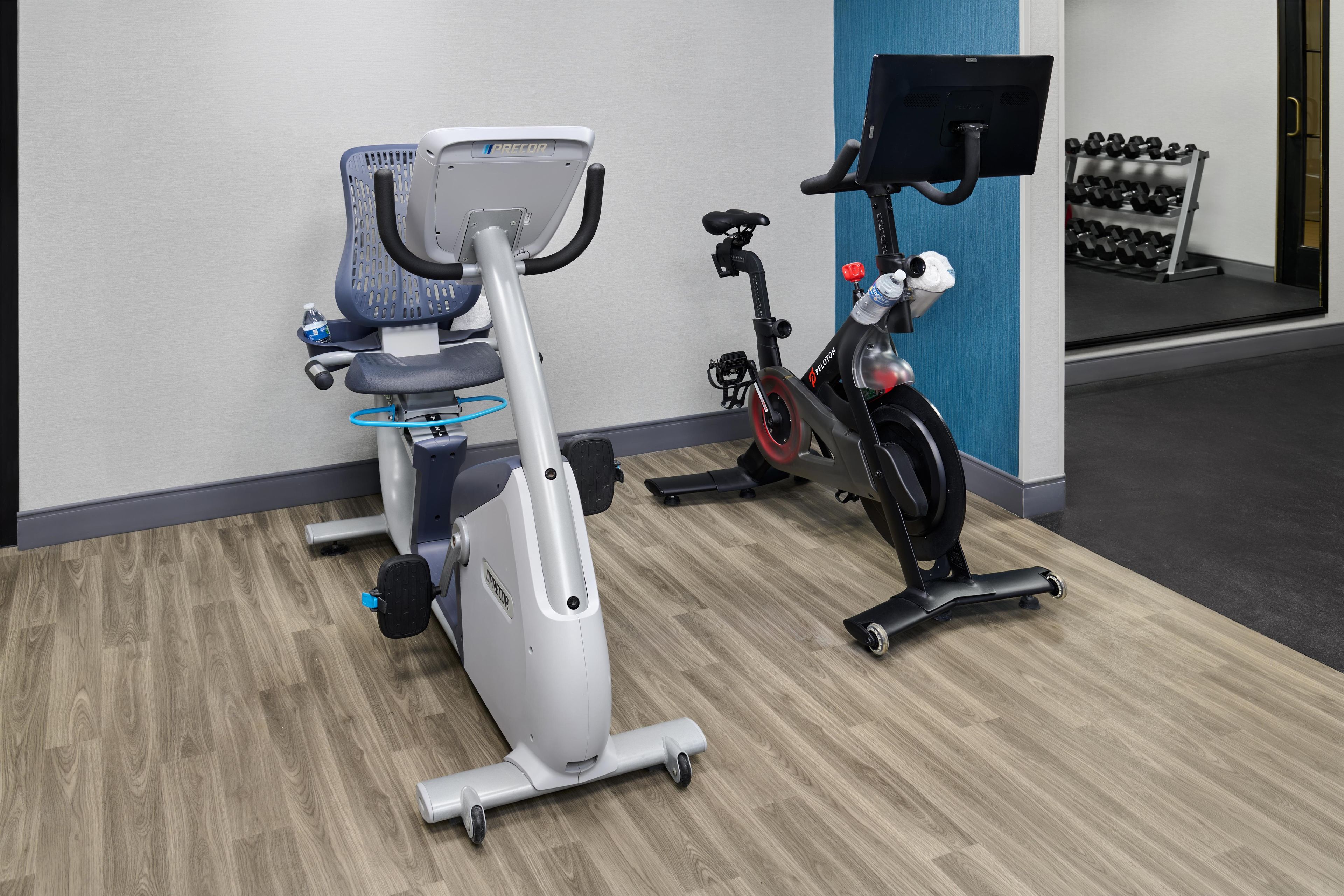 An exercise room with stationary bikes and a treadmill.