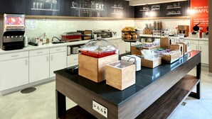 A modern cafe with a black and white color scheme, featuring a coffee machine, various food containers, and a chalkboard menu. - Hampton Inn & Suites Parsippany/North (Parsippany)