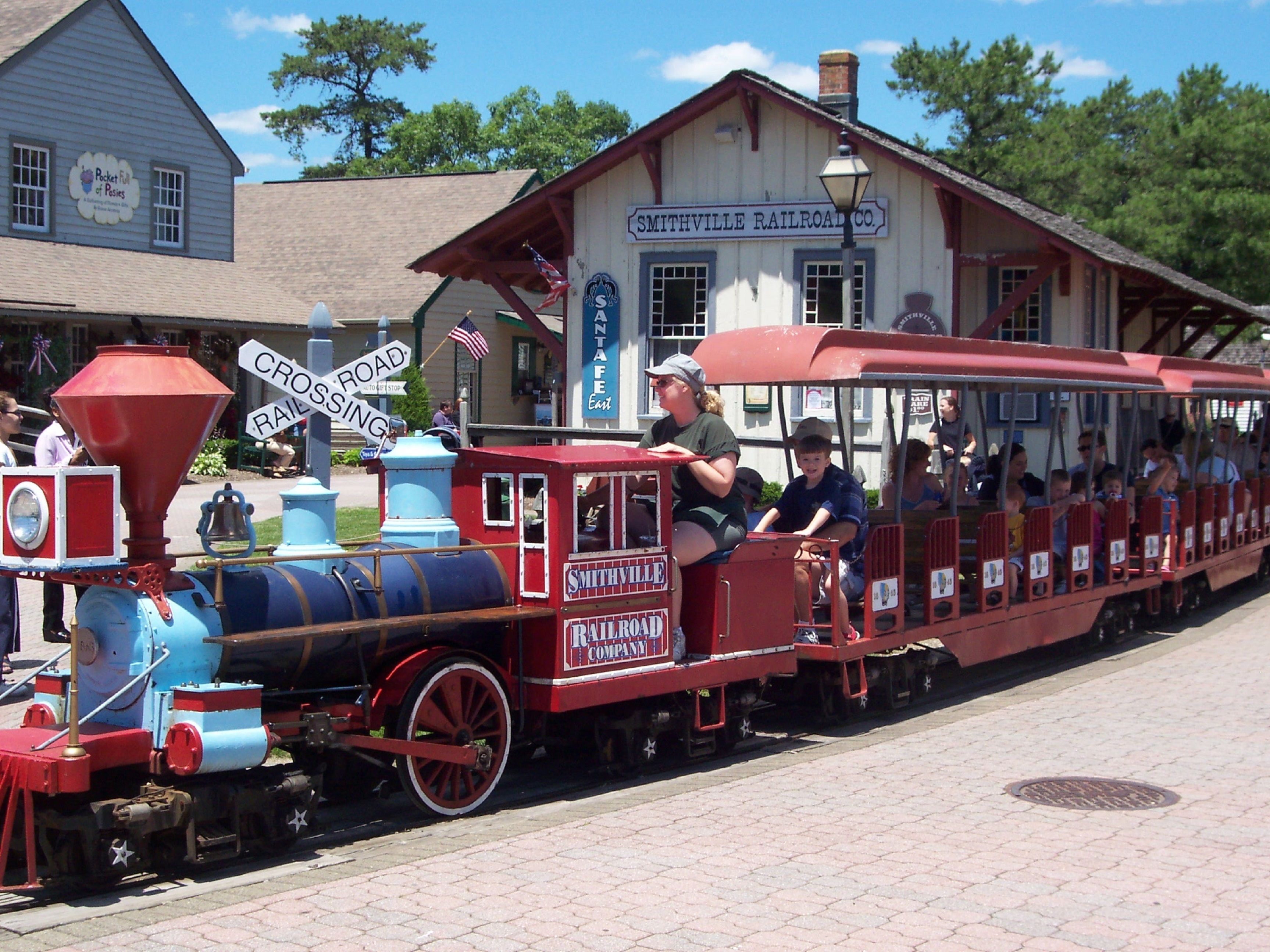 Een miniatuurtreinrit in een themapark, met een stationsgebouw dat "Smithville Railroad Co." zegt.