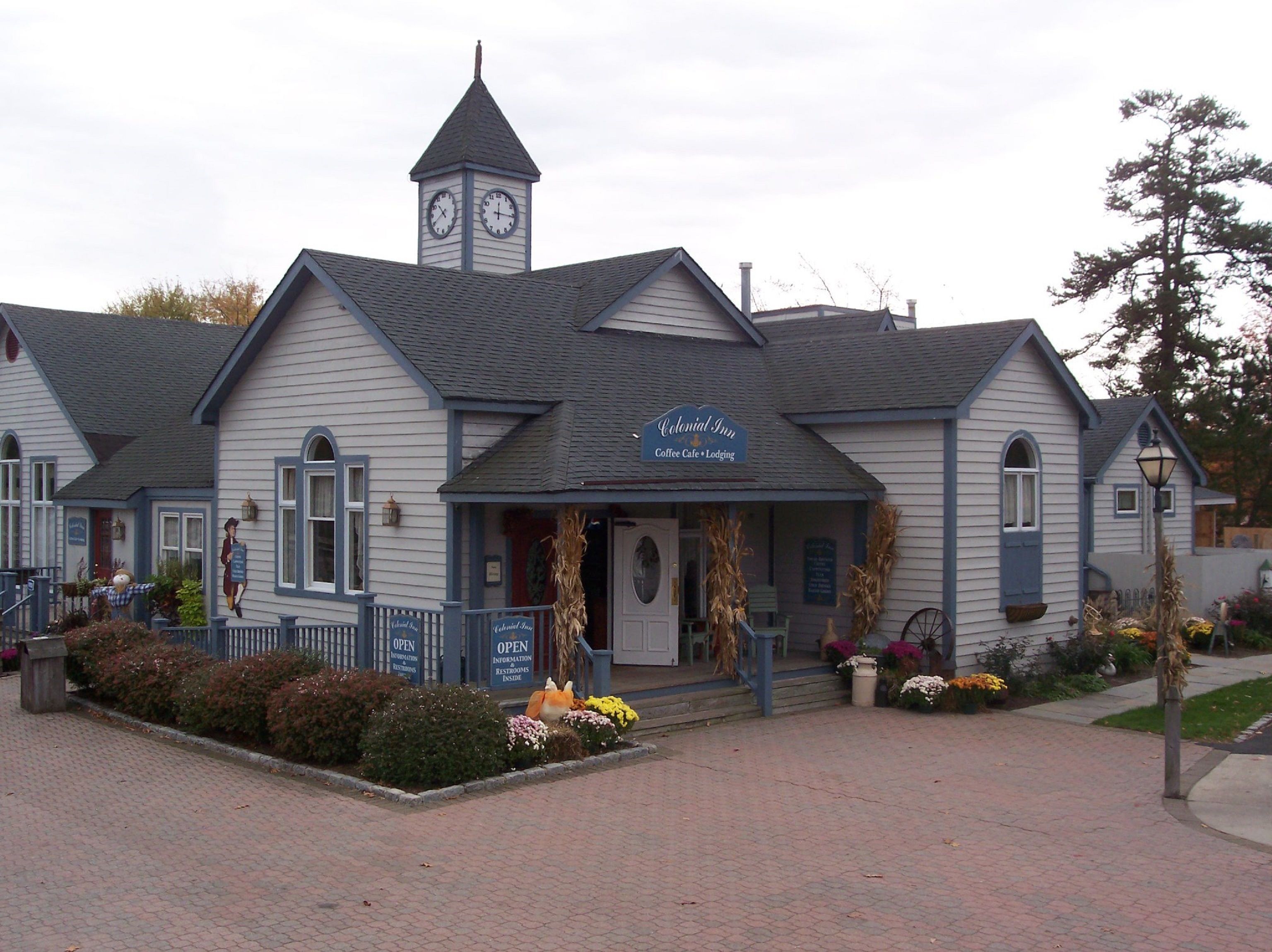 A Colonial Inn with a clock tower, a coffee shop, and a welcoming entrance with a porch.