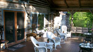 A covered outdoor patio with wicker furniture, a table, and a fan. - Chalet of Canandaigua (Canandaigua)