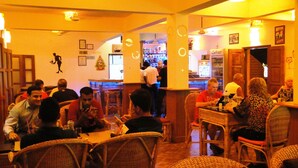 A restaurant interior with wicker furniture, a bar area, and a visible refrigerator labeled 'Celfrost'. - Ruffles Beach Resort (Candolim)