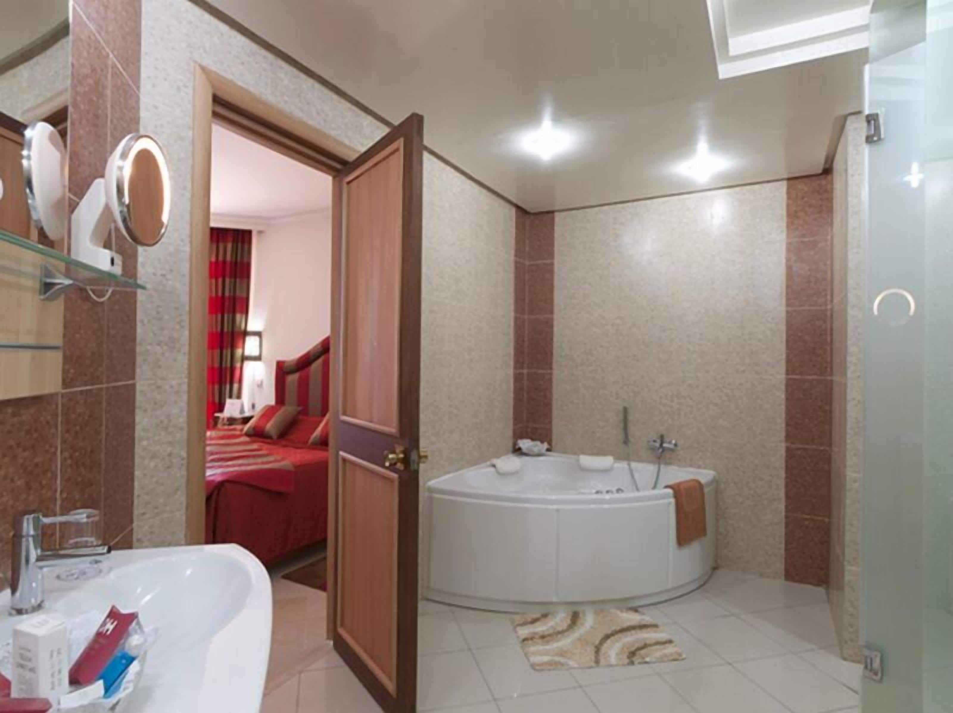 A bathroom with a bathtub, a shower, and a sink.