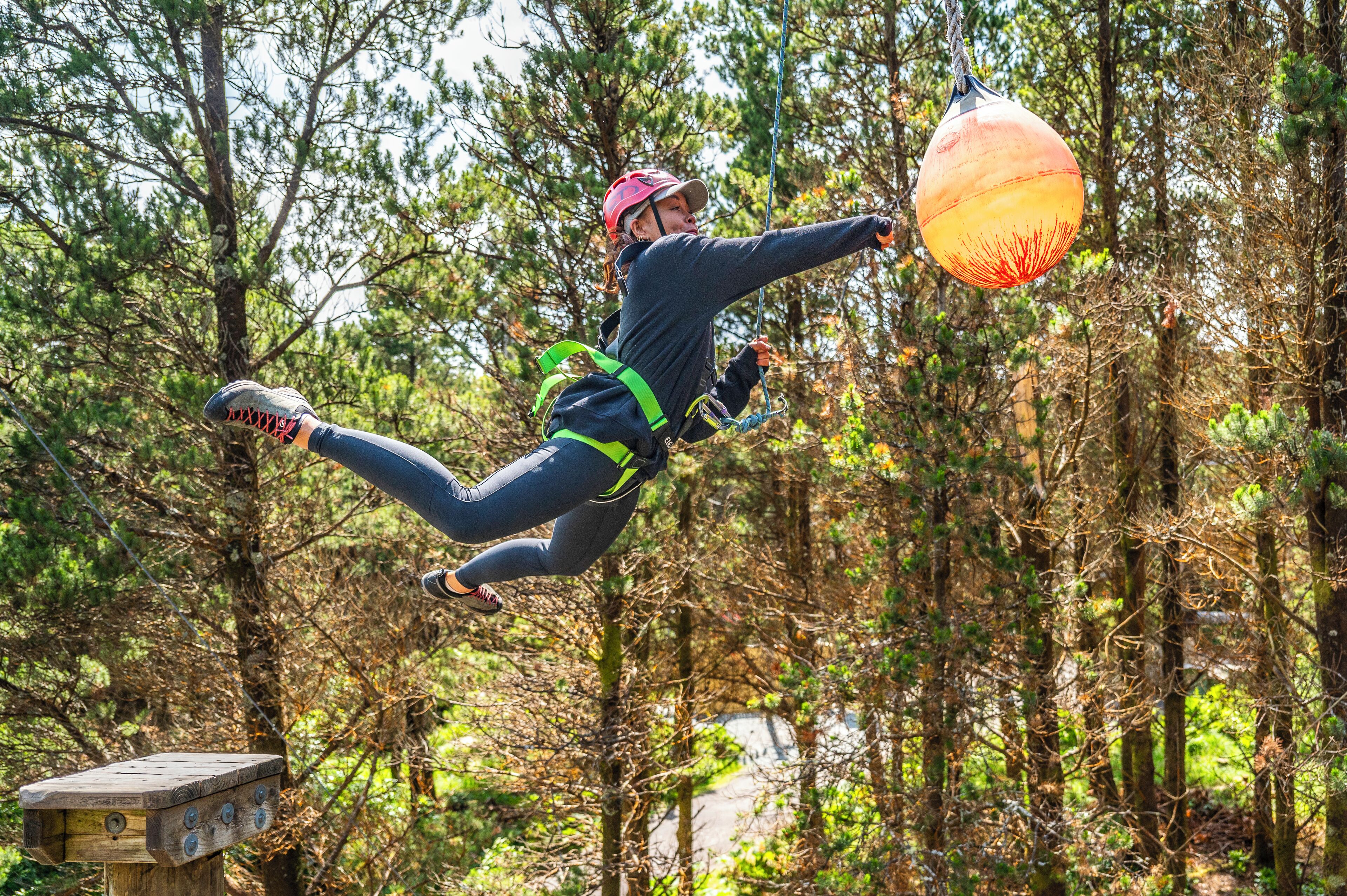 Una persona haciendo bungee jumping en una zona boscosa.