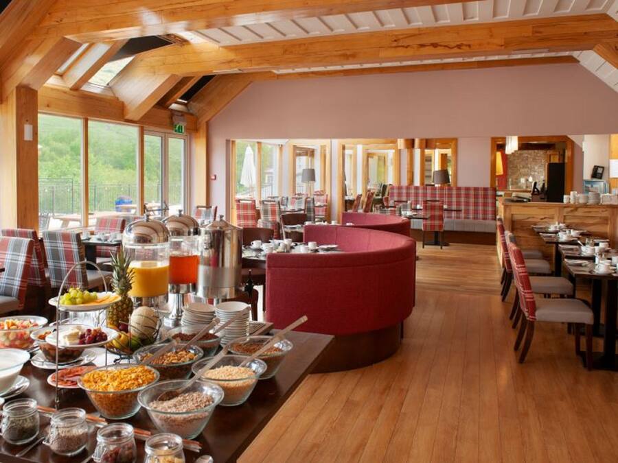 A breakfast buffet with various food items and seating arrangements in a wooden interior.