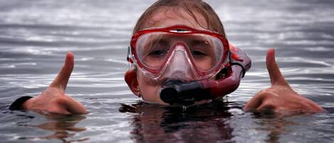 A person in a body of water with a cloudy sky in the background.