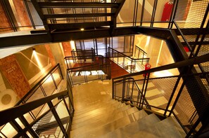 A multi-level indoor staircase with metal railings and a wooden floor.