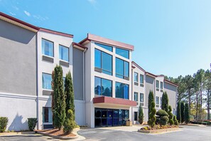 Un edificio moderno con varias ventanas y un estacionamiento.