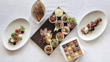 A variety of appetizers and desserts on a white table.