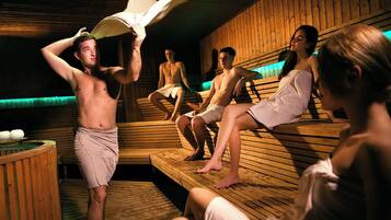 Una sauna con bancos de madera y una persona sosteniendo una toalla.