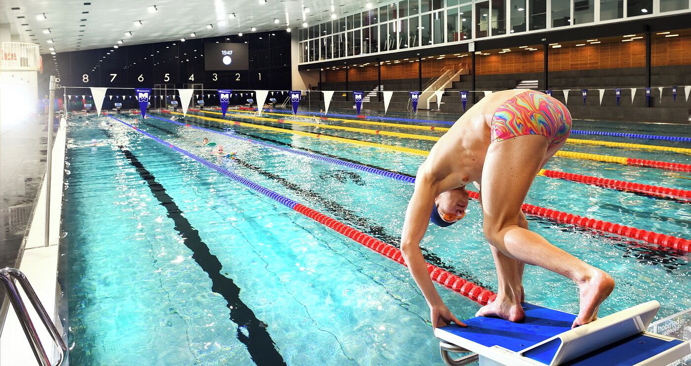 Ein Schwimmbecken mit Bahnen und einer digitalen Uhr, die 15:47 Uhr anzeigt.
